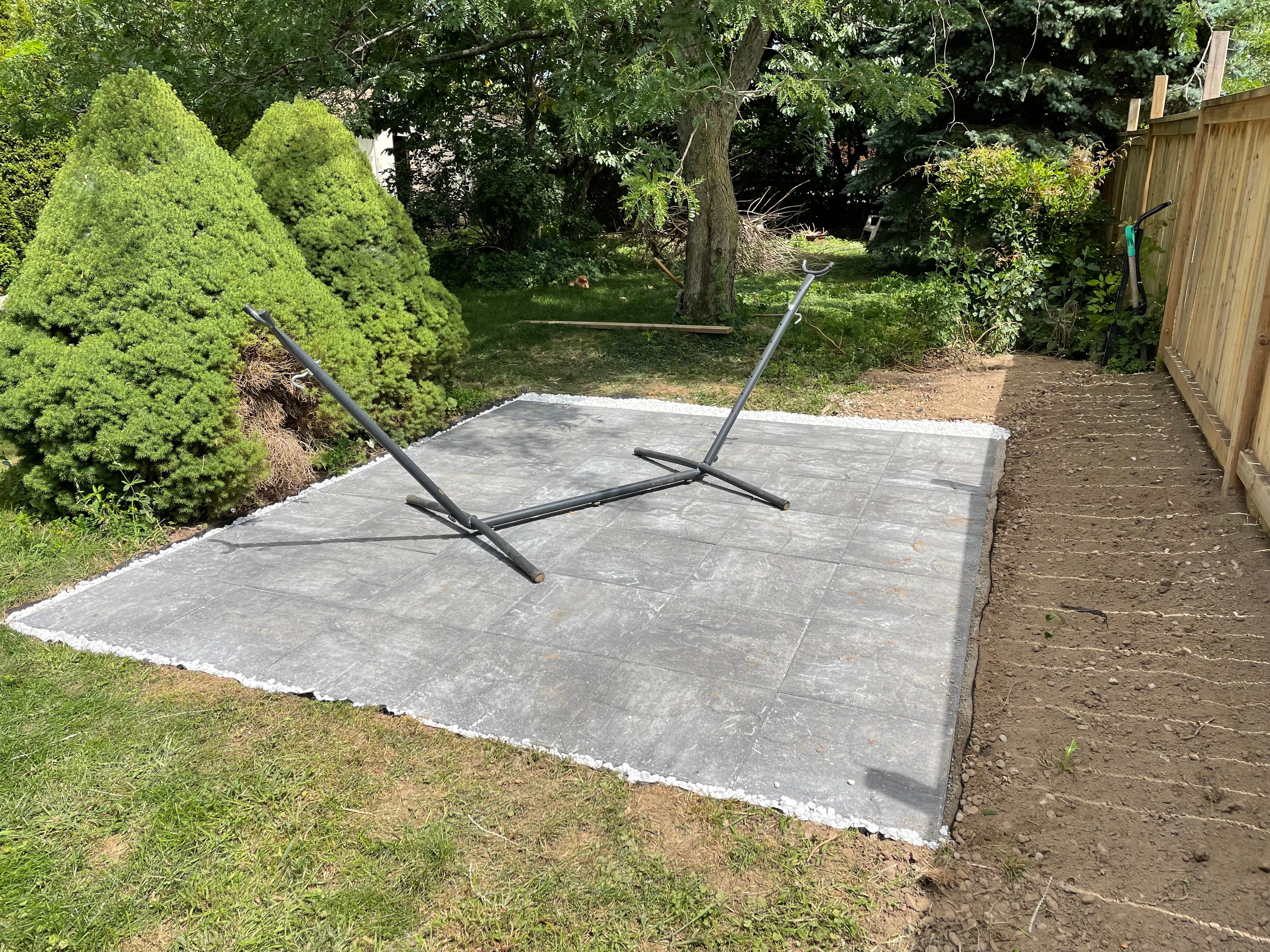 Brant County backyard after landscaping — new patio stone pad with white gravel border