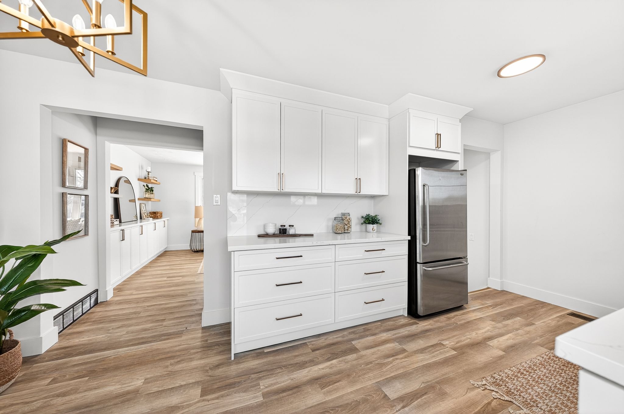 Cambridge kitchen renovation — white shaker cabinets, quartz countertops, stainless appliances, open to living area with built-ins visible