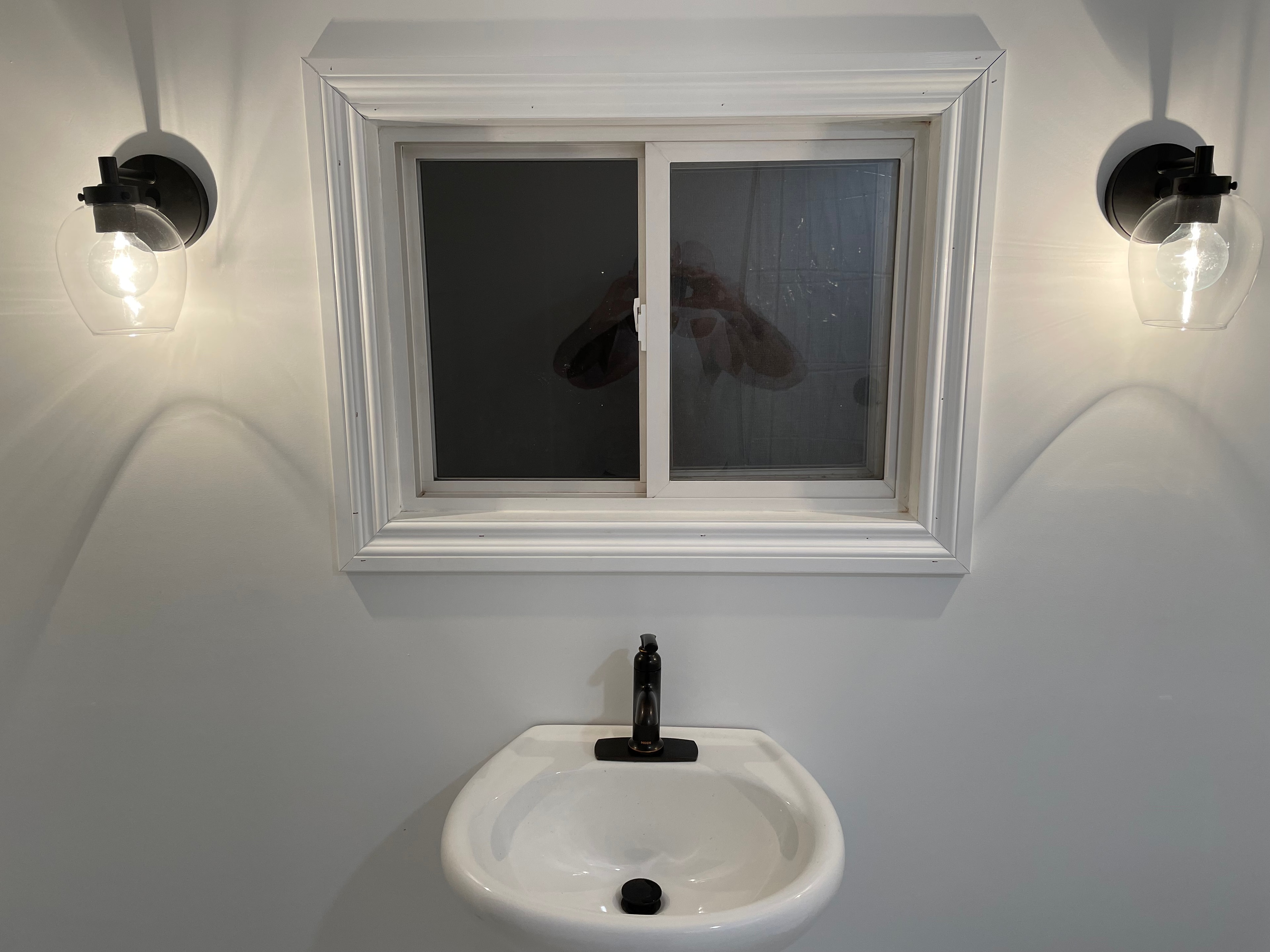 Paris ensuite after renovation — vanity with sconce lighting and new window trim